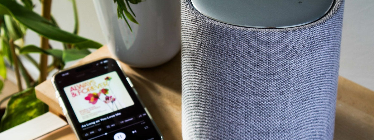 Parlante inteligente junto a un celular reproduciendo música
