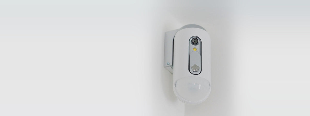 Cámara de seguridad blanca instalada en la pared