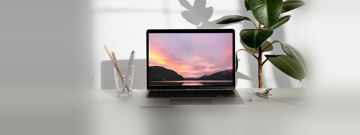 Laptop abierta con pantalla encendida sobre escritorio iluminado